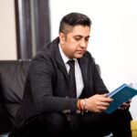 A founder sitting at a desk in natural light with a notebook and laptop, reflecting on decisions and challenges. The image represents the human side of entrepreneurship, decision fatigue and the realities of building businesses.